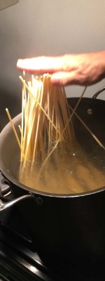 The Pasta is placed in the salty boiling water. Now we push her down gently.